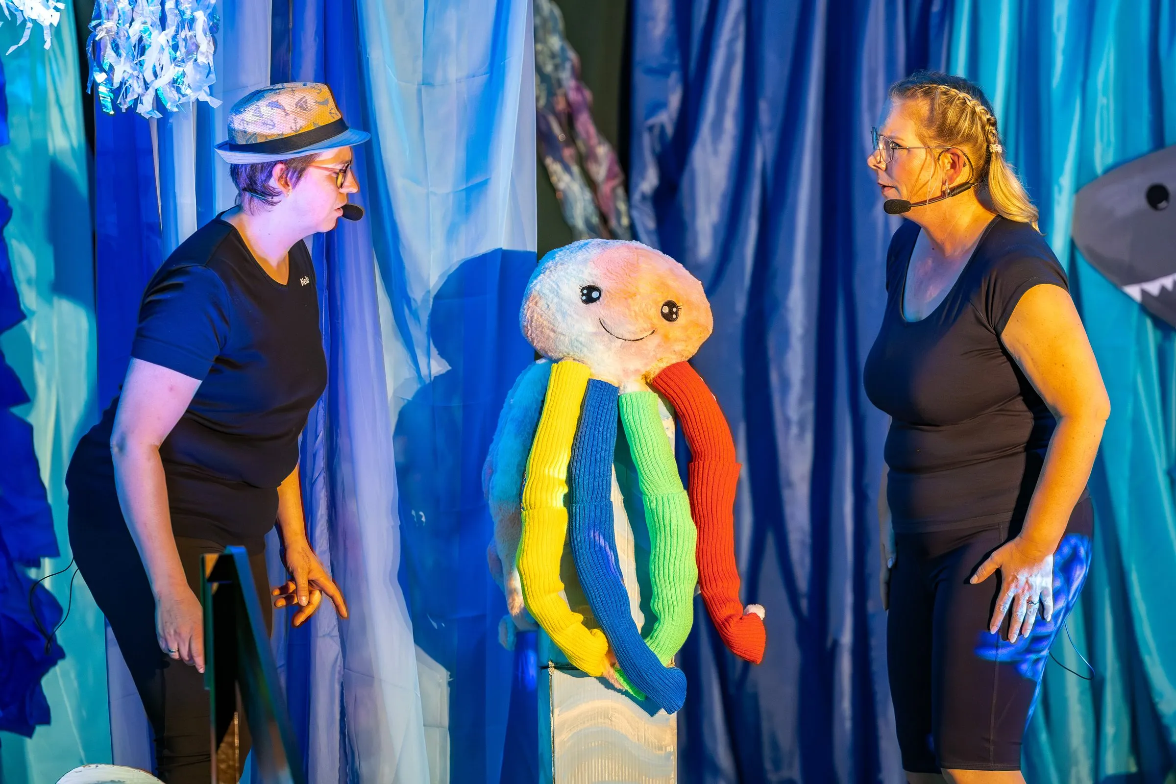 Der Oktopus-Puppenkopf mit den bunten Fangarmen zwischen den beiden Taucherinnen.
