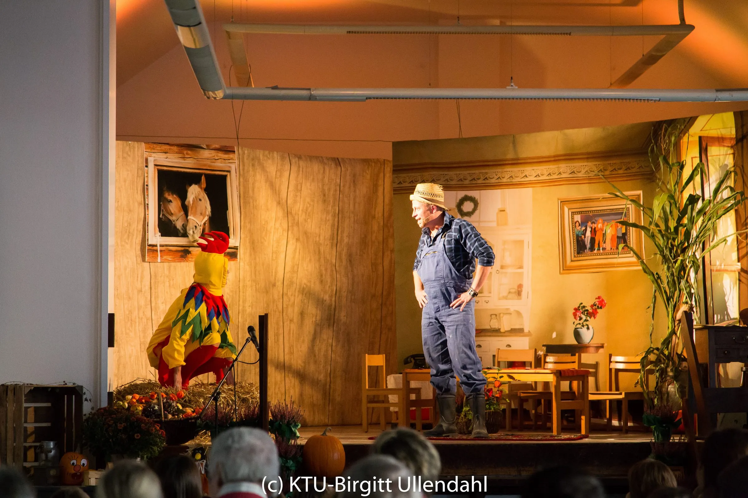 Der Hahn im bunten Kostüm am Stallfenster mit zwei Pferden, daneben Bauer Anton in Latzhose und Strohhut in der Bauernstube.