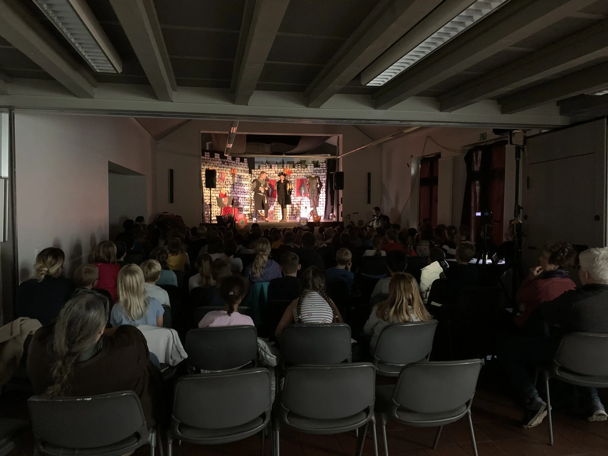 Blick vom vollbesetzten Zuschauerraum auf die Bühne mit Ritter Veritas und Knappe Mathes.